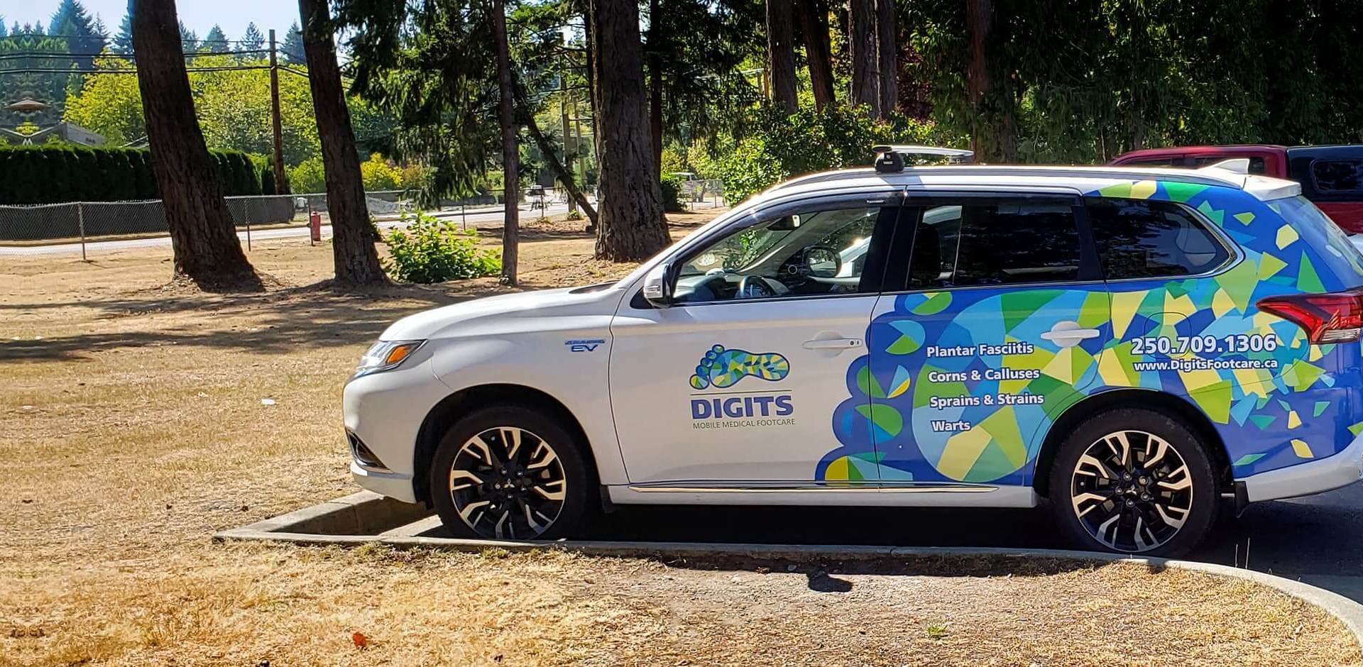 Digits vehicle in parking lot next to some trees